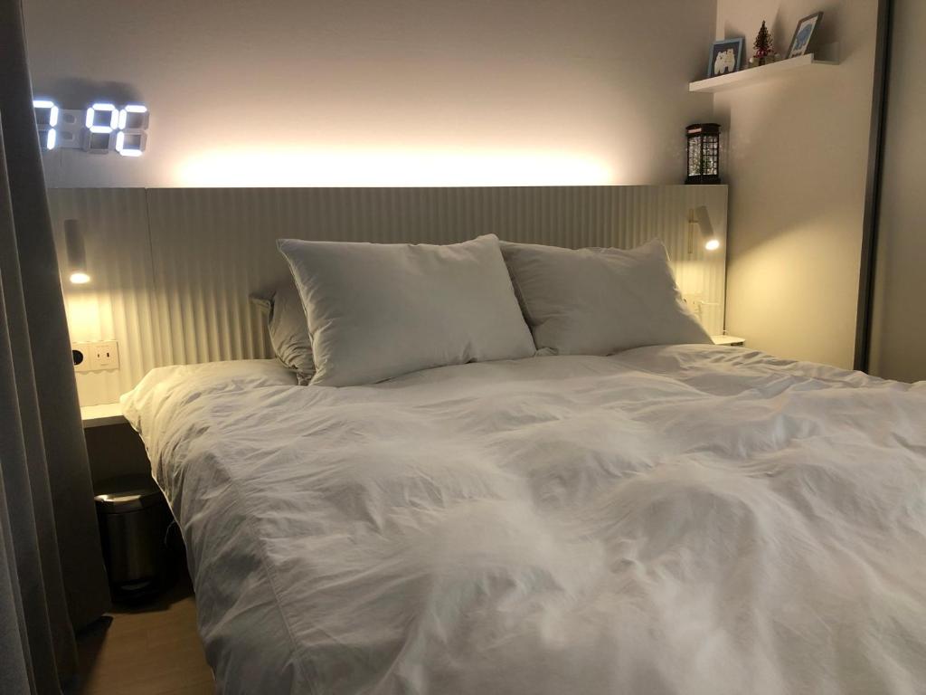 釜山Harington Gwangan的一张白色大床,配有白色床单和枕头