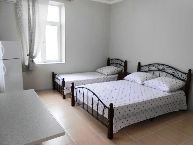 加格拉Guest House Gorny Ruchei的一间卧室设有三张床和窗户。