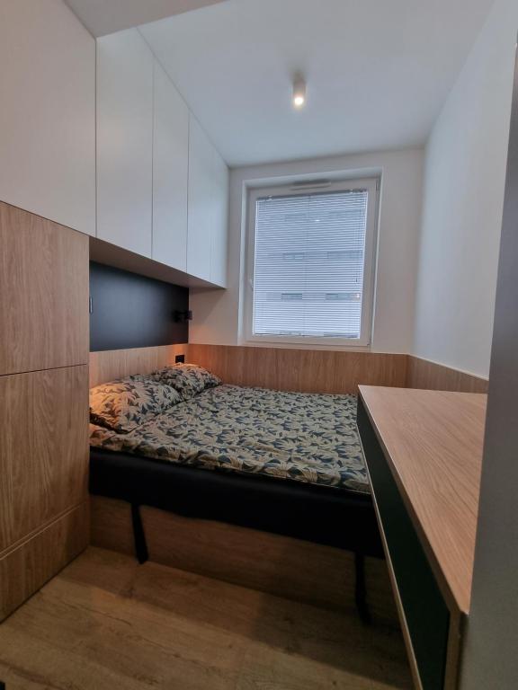 克拉科夫Stańczyka Apartment的一个小房间,在带窗户的房间里设有一张床