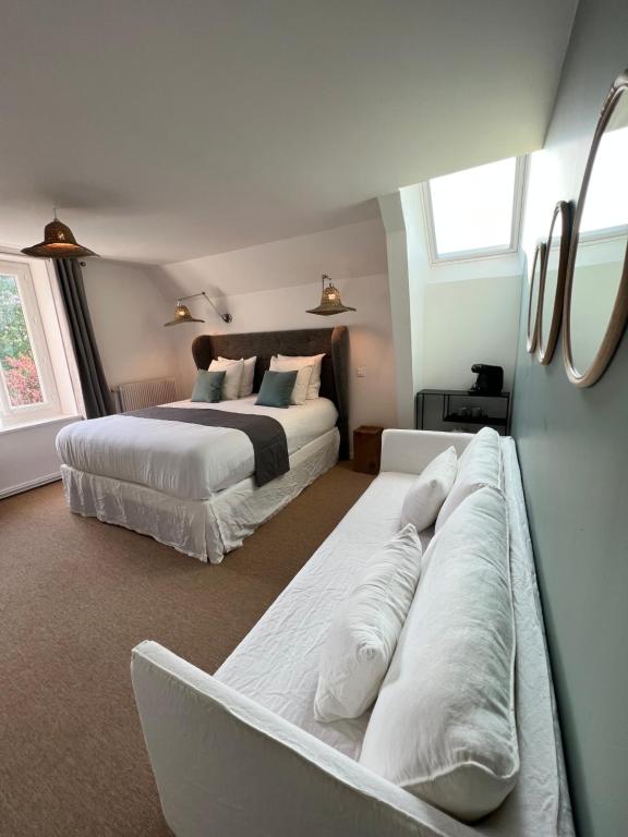 IsquesManoir Les Feuillantines Piscine & Spa的一间卧室配有两张床和一张沙发。