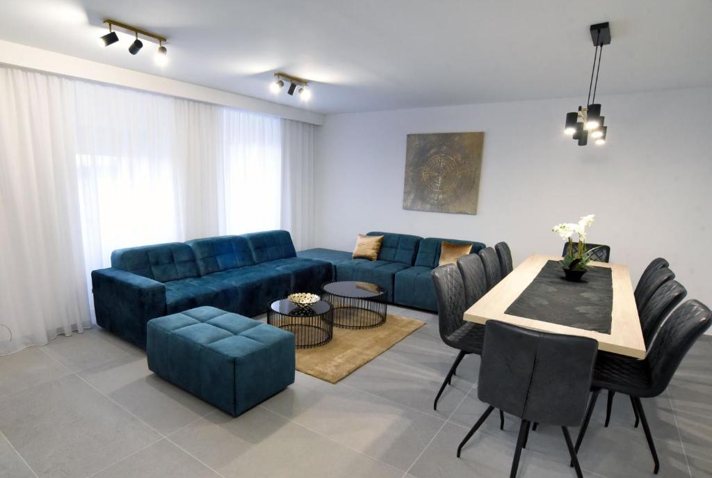 里耶卡Commodious house in Rijeka with 5 bedrooms的客厅配有蓝色的沙发和桌子