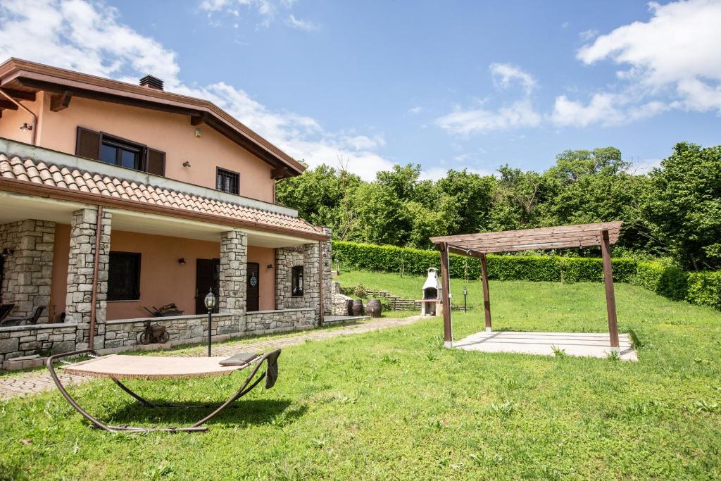 Prata di Principato UltraVilla Le Cicale - Irpinia的房屋旁的花园设有桌子和凉亭