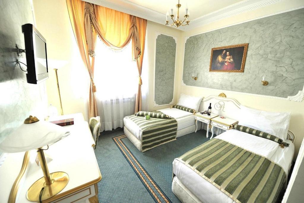 贝尔格莱德皇后阿斯托利亚设计酒店的酒店客房,设有两张床和一张沙发