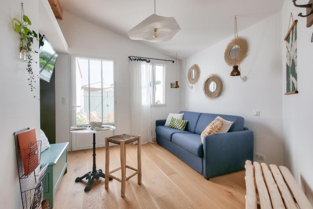 里夫杜海滩Studio avec terrasse à 250 mètres du port的客厅配有蓝色的沙发和桌子