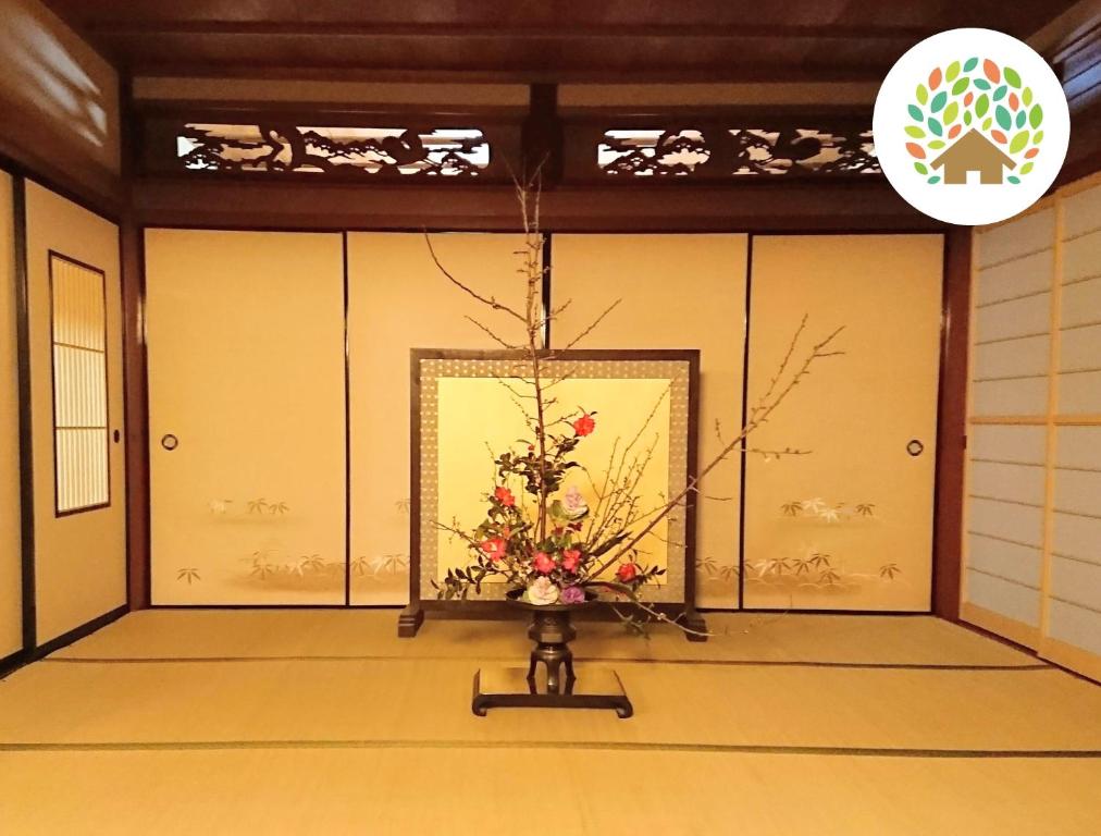 高岛市Farm stay inn Sanzaemon-tei 母屋GuestHouse Shiga-Takasima Traditional Japanese architecture house的花瓶里放着鲜花的房间