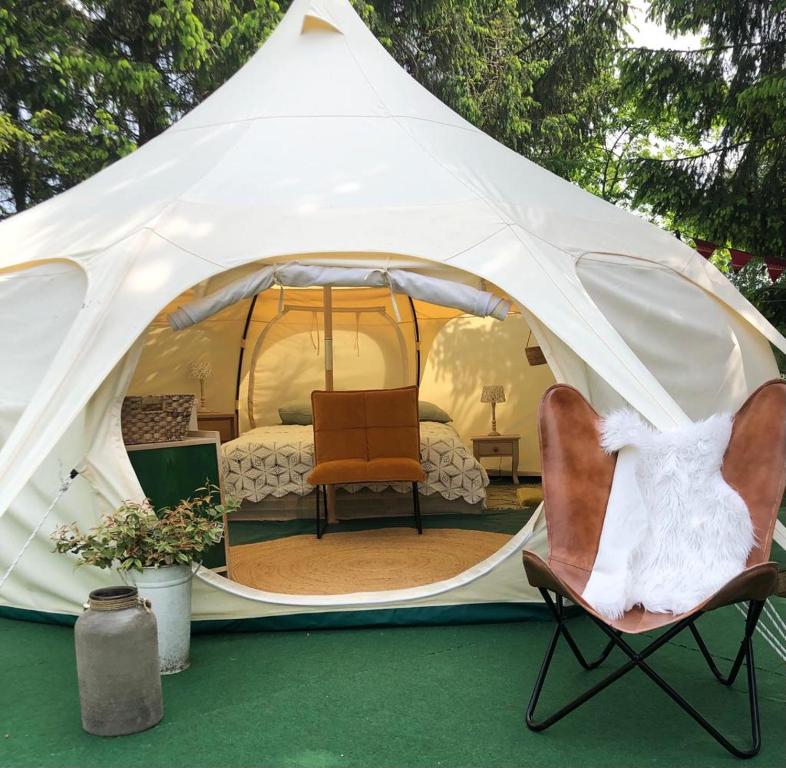 Minicamping Kleintje Zandpol的帐篷配有两把椅子和一张床