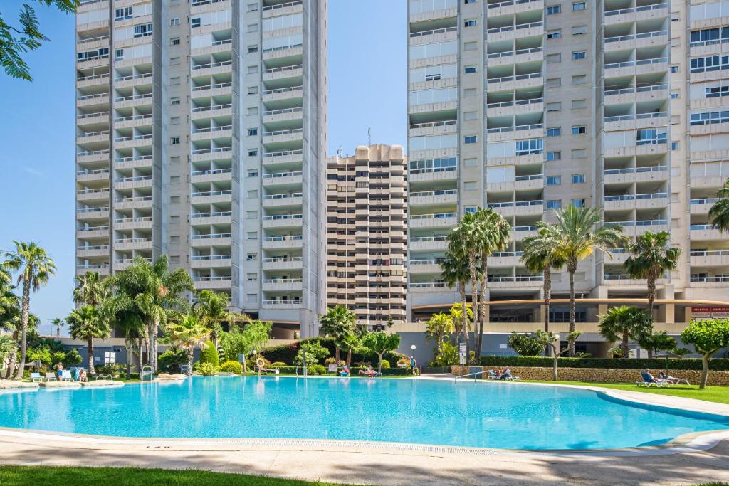 贝尼多姆Gemelos 22 Resort Apartment 3-1C Levante Beach的一座游泳池,位于一些高楼前