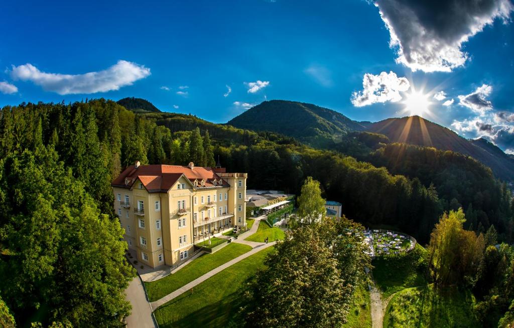 里姆斯克·托普利采Rimske Terme Resort - Hotel Sofijin dvor的山上的一座建筑,阳光照耀着天空