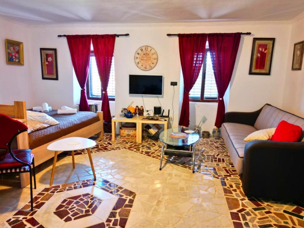 威尔帕扎Dabanović House的客厅配有红色窗帘和沙发