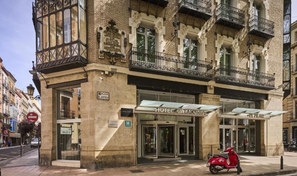 萨拉戈萨加泰罗尼亚支柱酒店的停在大楼前的一辆红色摩托车