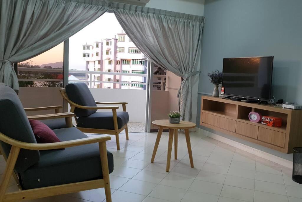 Kapayan2. Luxury Kristal Condo 2 丹绒亚路高級市中心住宅的客厅配有2把椅子和平面电视