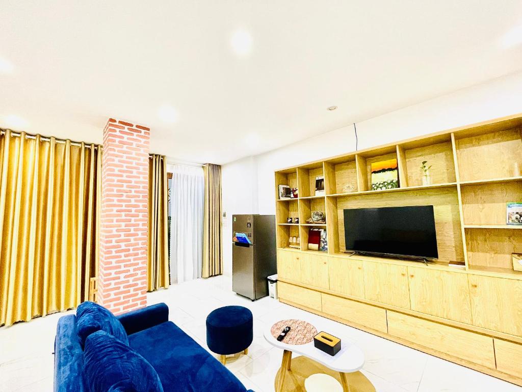 岘港TINA HOUSE Apartment的客厅配有蓝色的沙发和电视