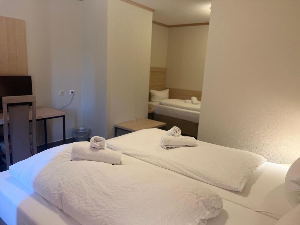 阿沙芬堡桑德豪斯阿尔特斯酒店的一间卧室配有两张白色床和毛巾