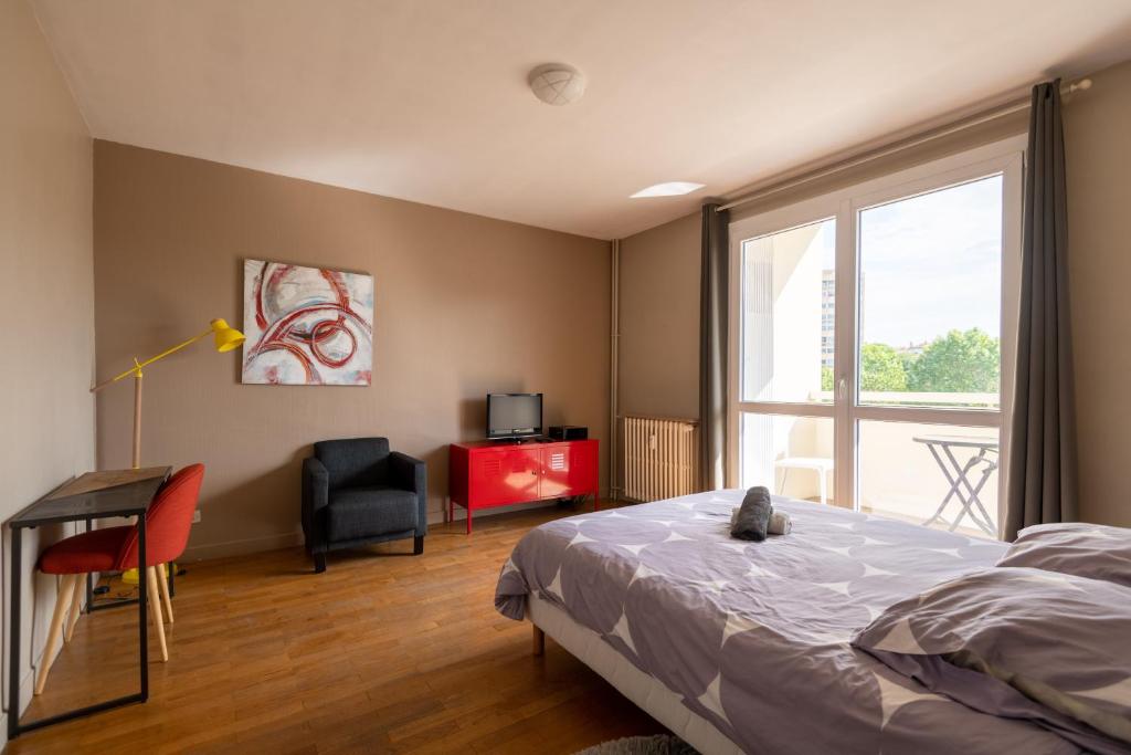圣艾蒂安Appart'hotel de Montplaisir的一间卧室配有一张床、一张书桌和一个窗户。