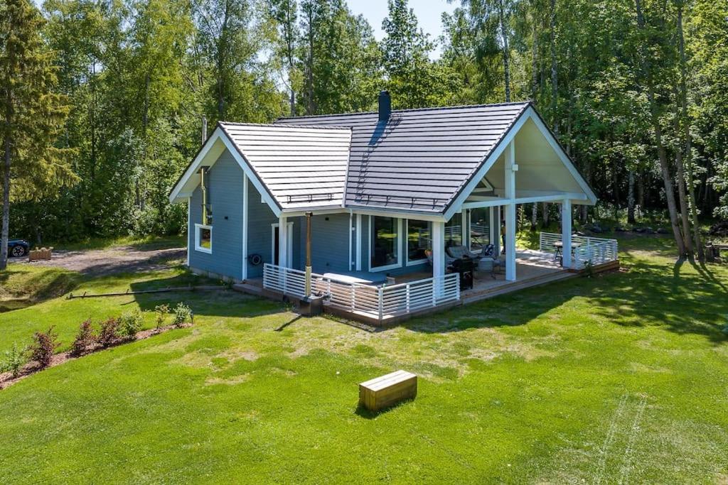 HiiumaaModern villa with sauna & hot tub的草地庭院上的小蓝色房子