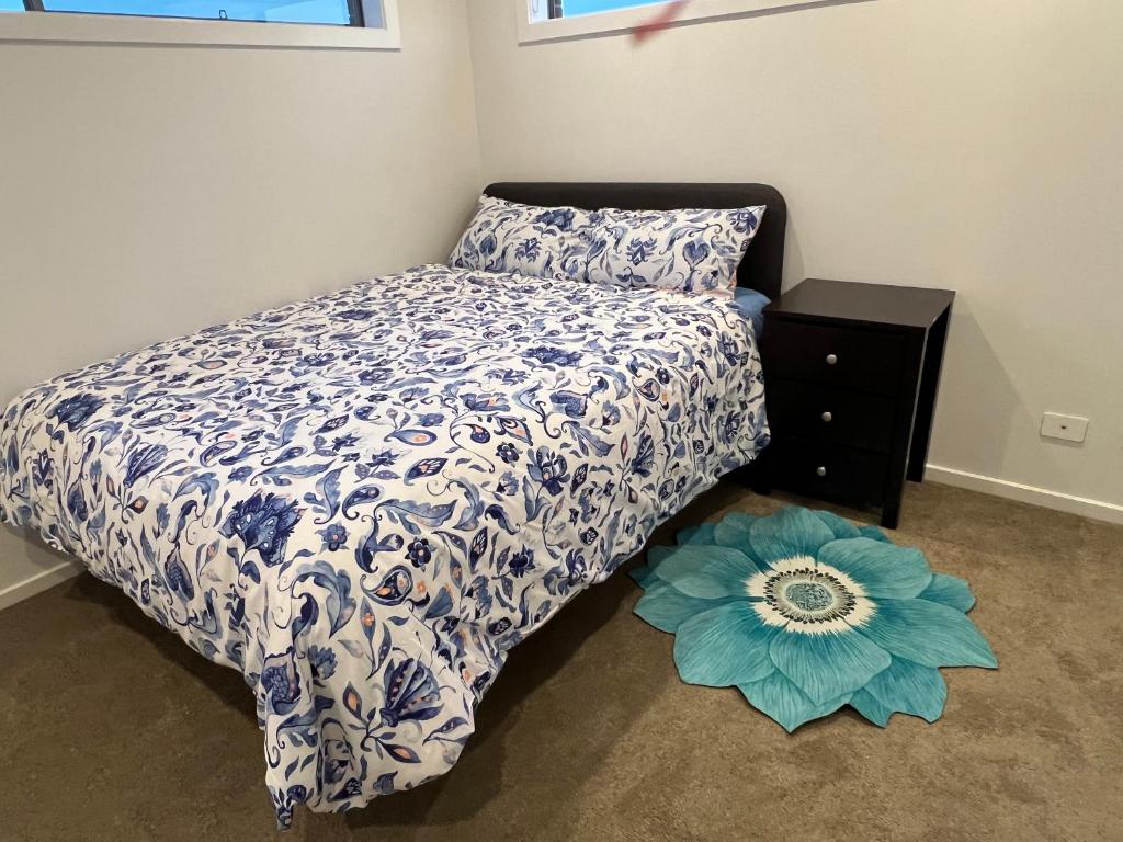CranbournePavilion paradise的一间卧室配有一张带蓝色和白色棉被的床