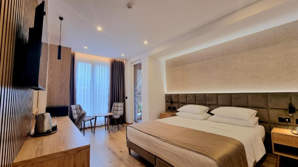 地拉那SIBB Hotel的酒店客房设有一张大床和一张书桌。