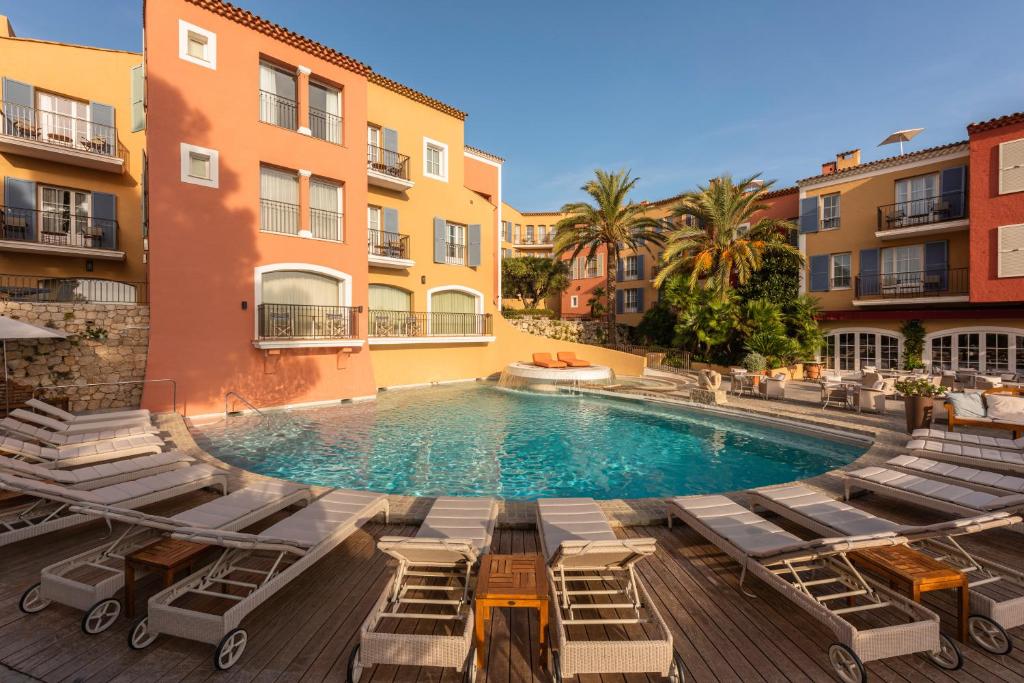 圣特罗佩圣特罗佩比布鲁斯酒店的一座带躺椅的游泳池和一座建筑