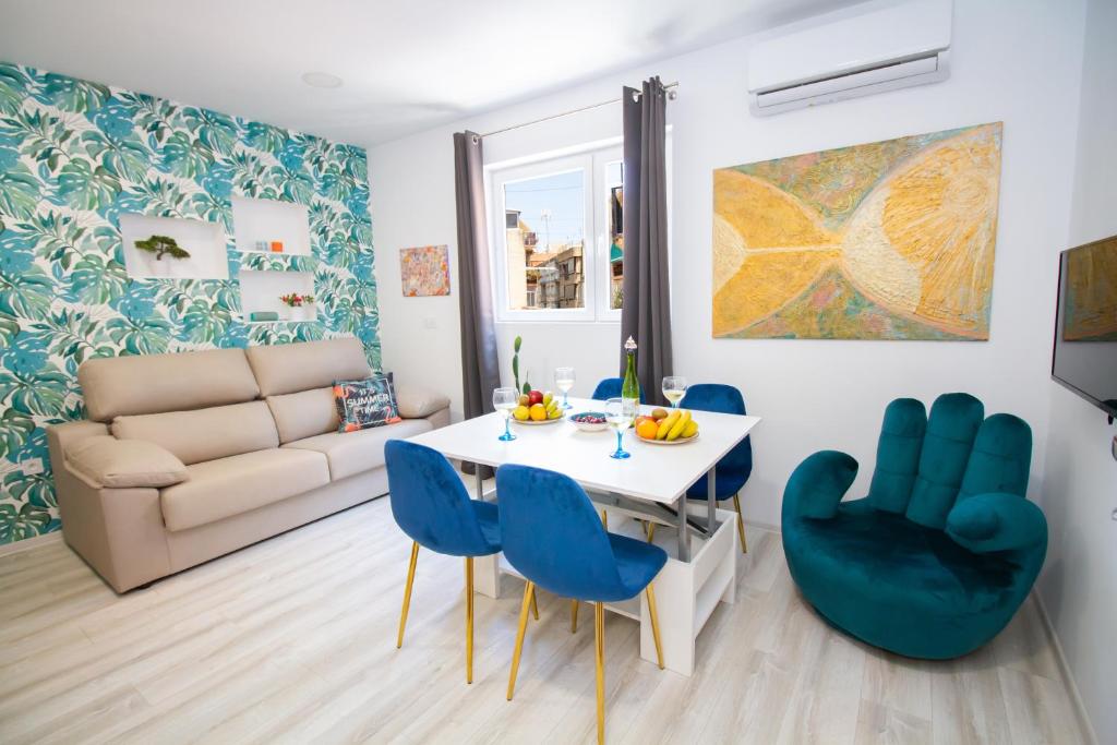 阿利坎特Art Apartments Alicante的客厅配有桌子和蓝色椅子