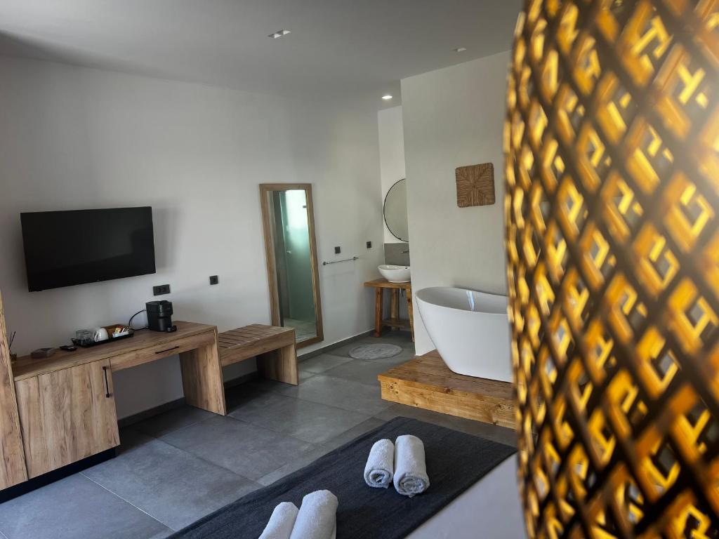 凯法洛斯Sydney Hotel的客房设有浴缸、电视和浴室。