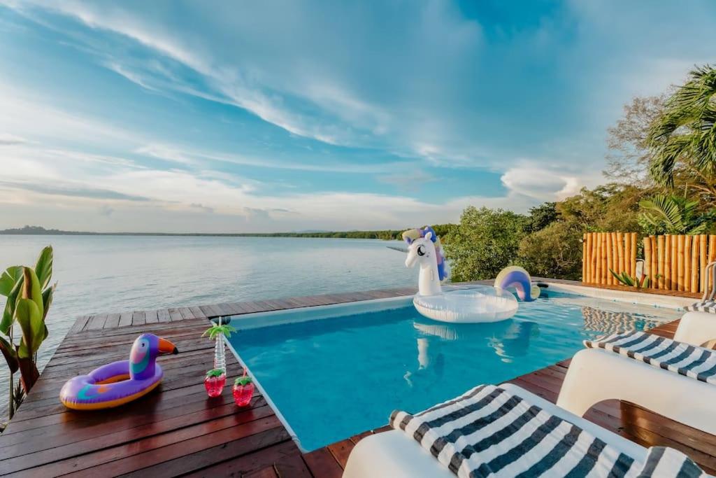 波德申Bamboo Rimbun-Tranquil Seaside Villa, Port Dickson的甲板上设有天鹅和充气鸭子的游泳池