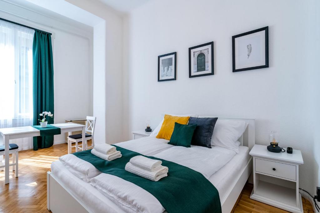 布达佩斯Budafoki Residence的白色卧室配有一张大床和一张桌子