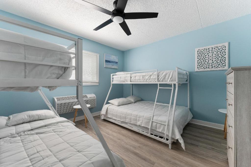 北怀尔德伍德Harbor Light Family Resort的一间卧室设有两张双层床和吊扇