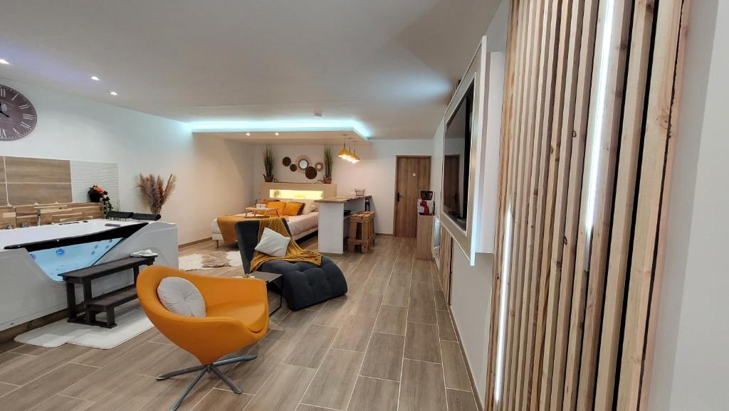 La BasséeGrand Studio magnifique avec Spa privatif illimité的客厅配有橙色椅子和沙发