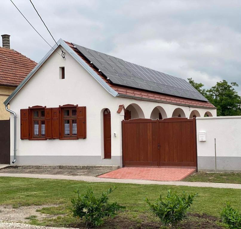 SZÍVES LAK的白色的房子,设有木门和围栏
