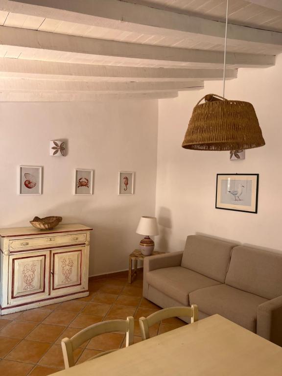 马达莱纳Appartamento il Paguro a Cala Francese的客厅配有沙发和桌子