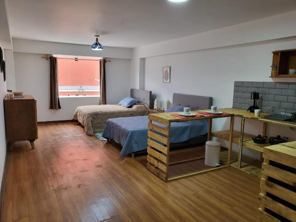 利马Espaciosos y lindos mini apartamentos的一间设有两张床和一张桌子的房间