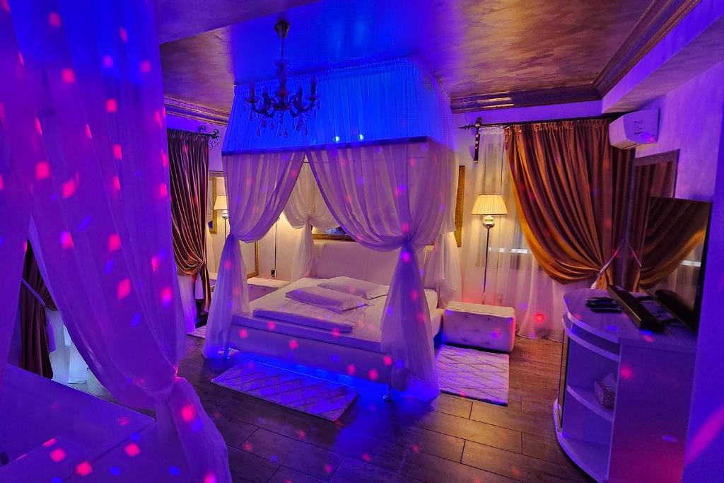 布拉索夫Hotel Boutique Mikaela (Adult Only)的一间卧室配有一张紫色照明床