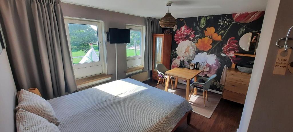 海边的艾格蒙特Villa La Vida的一间卧室配有一张床、一张桌子和两个窗户