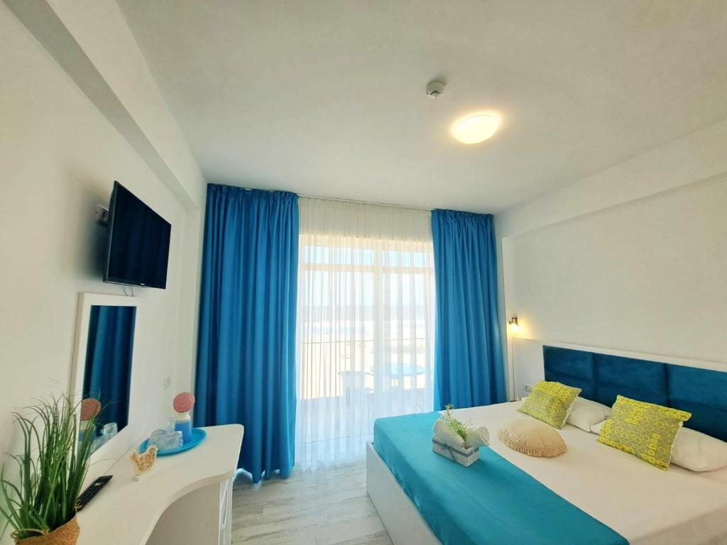 艾福雷诺德Vila Thassos Sea View pe plaja Belona的一间大卧室,配有蓝色窗帘和一张大床