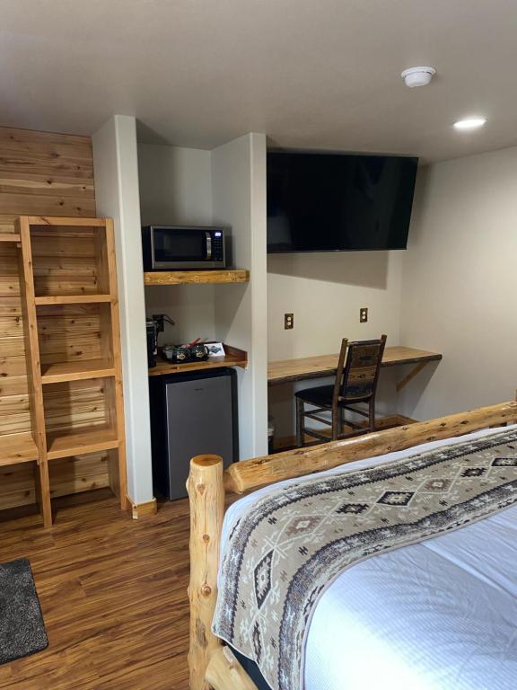 Summit Lake苏米特湖畔旅舍的客房设有一张床和一张带微波炉的书桌