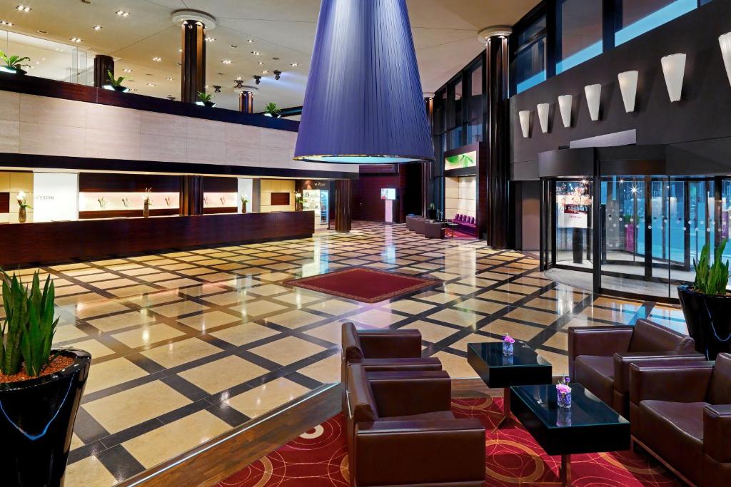 莱比锡莱比锡威斯汀酒店的大堂设有皮椅和 ⁇ 板地板