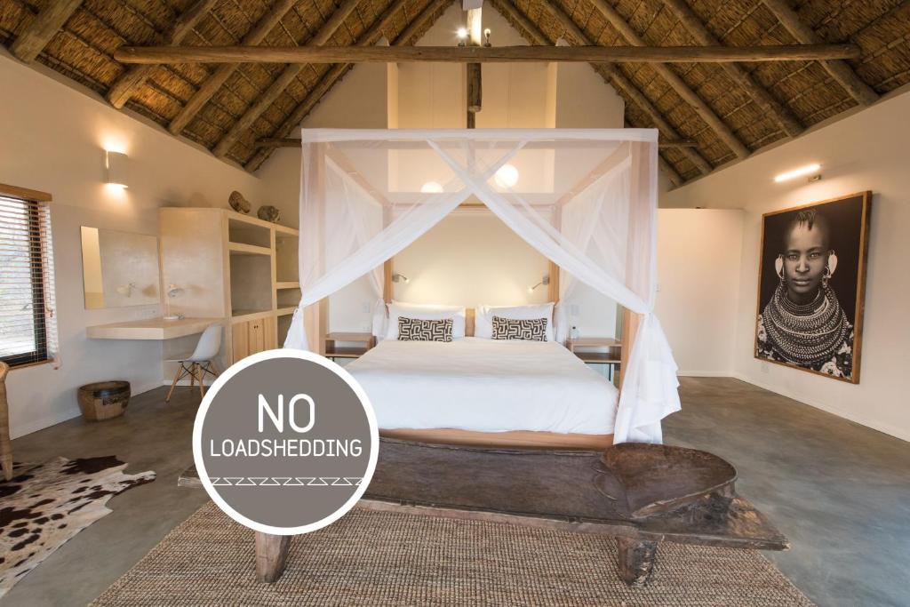 侯斯普瑞特Unembeza Boutique Lodge & Spa的一间卧室配有一张带天蓬的床