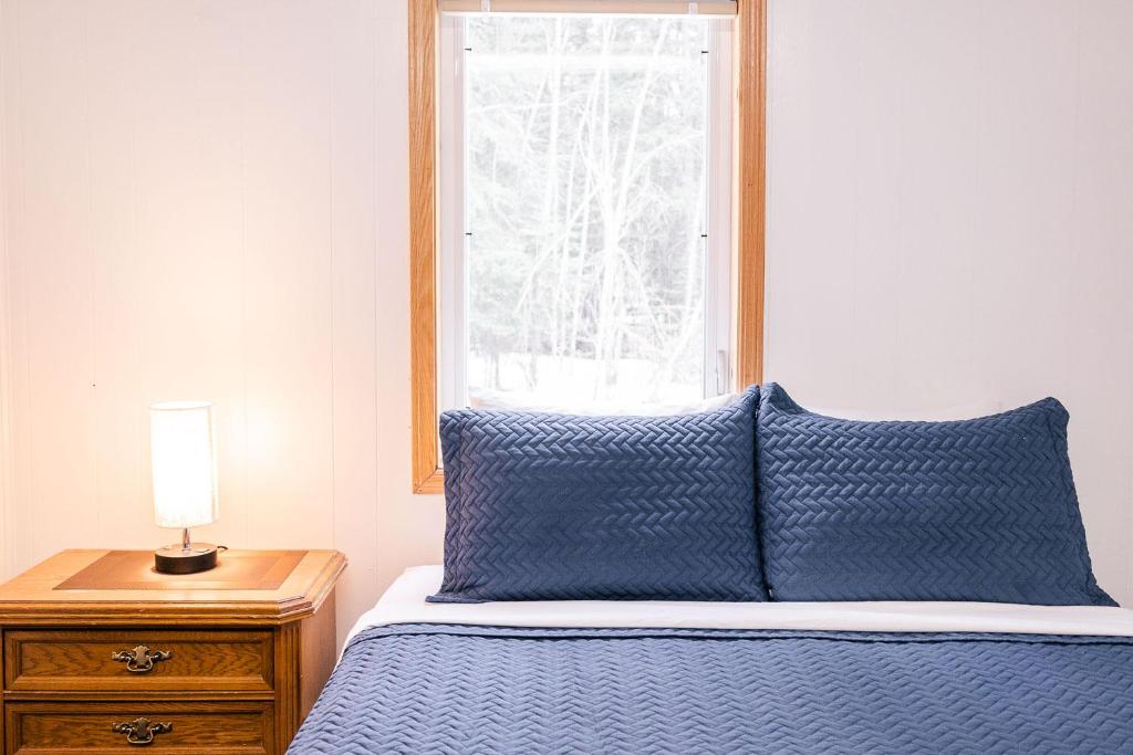 Delta JunctionDelta Lodge的一张带蓝色棉被的床和窗户