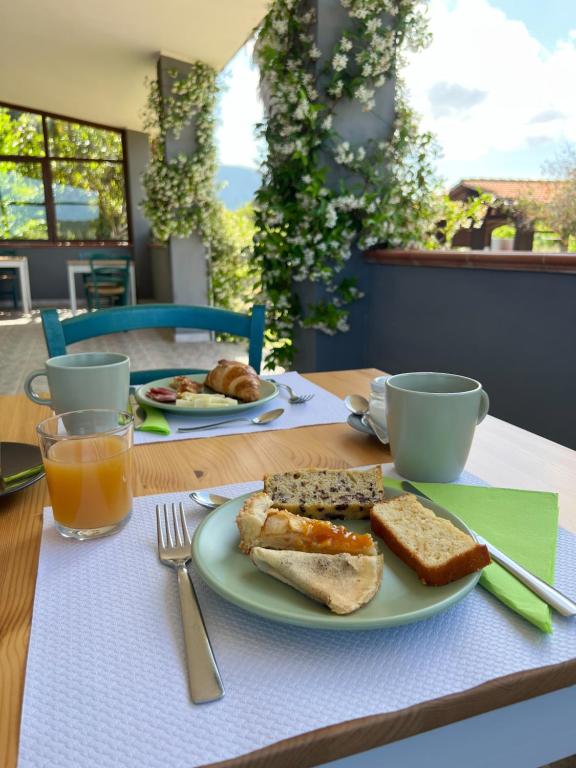 康特港格拉齐亚诺芭芭拉农家乐的一张桌子,上面放着一盘烤面包、咖啡和橙汁