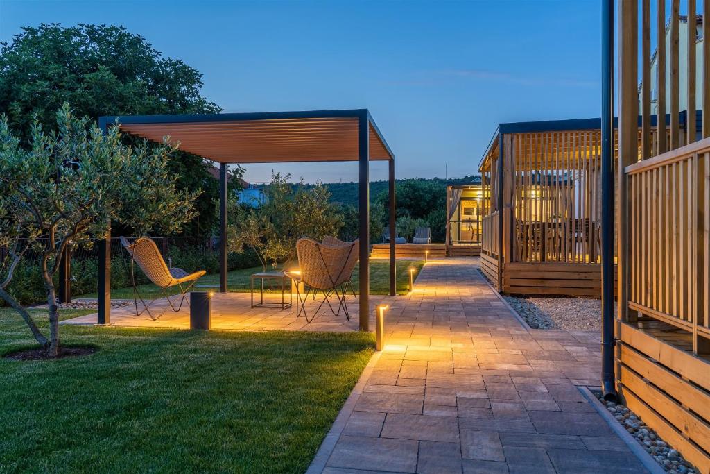 苏科尚Giardino Sukošan - new mobile houses in olive garden, EV plug-in station的一个带椅子的庭院和一个带灯的凉亭
