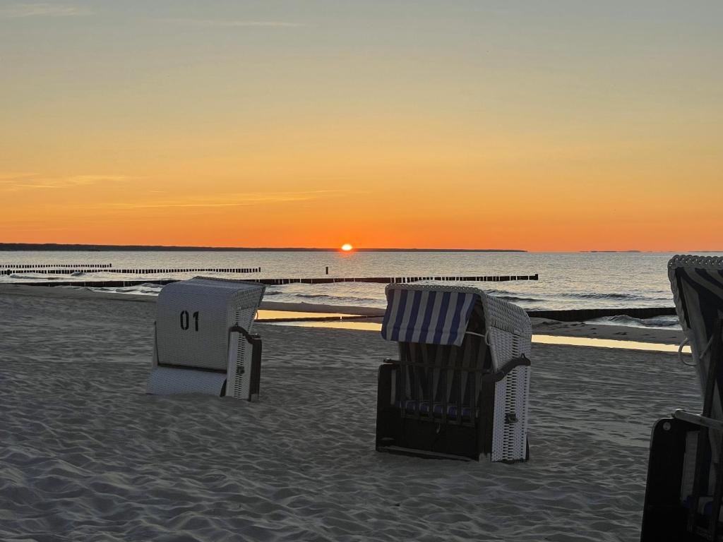 岑平Strandidyll的日落时分海滩上两把草坪椅