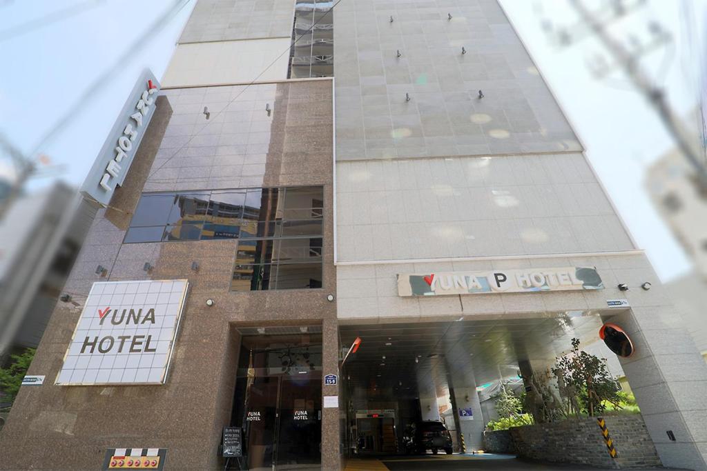 釜山HOTEL YUNA Business的前面有酒店标志的建筑