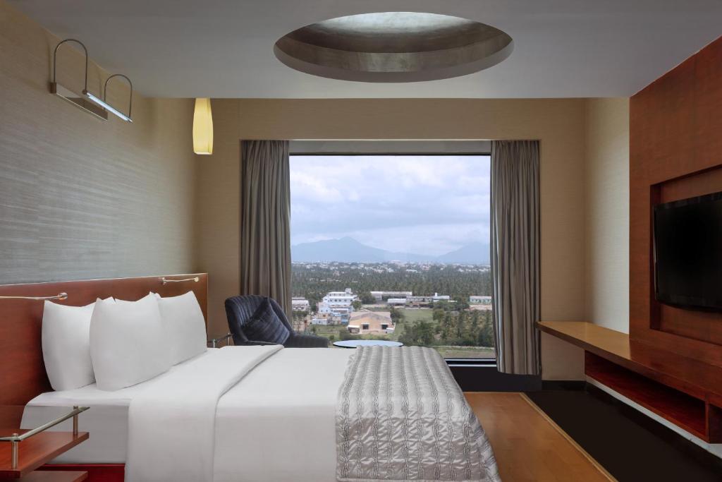 哥印拜陀哥印拜陀艾美度假酒店的酒店客房设有一张床和一个大窗户