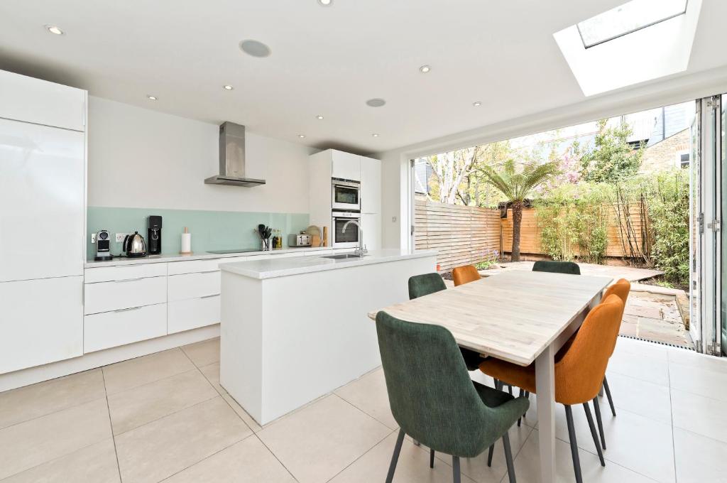 伦敦Family Home near Clapham Common by UnderTheDoormat的厨房以及带桌椅的用餐室。