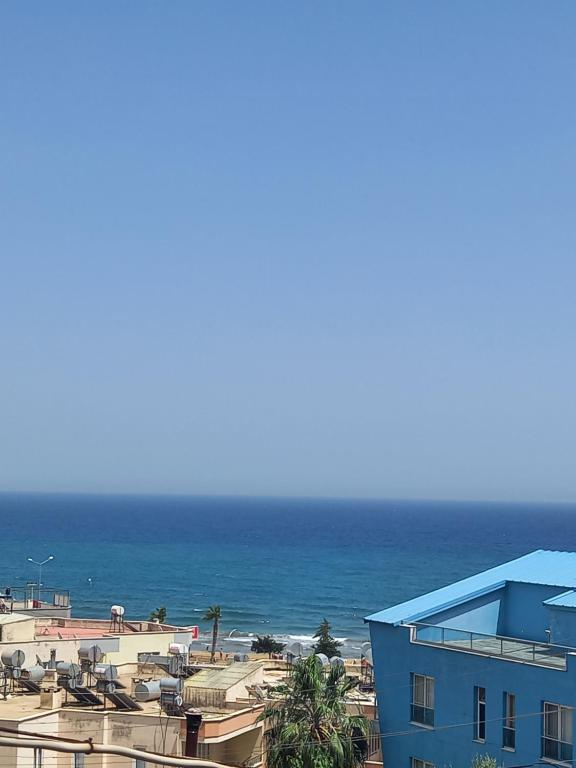 ErdemliYasemin Yazlık Pansiyon的享有海滩、蓝色建筑和大海的景色