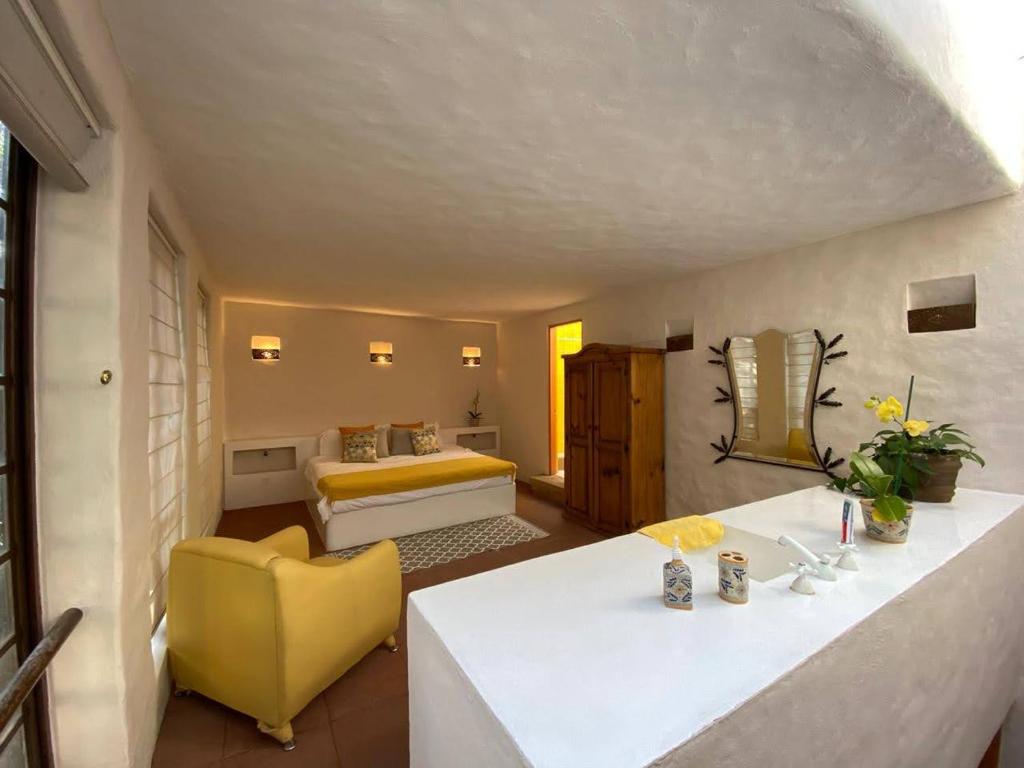 库埃纳瓦卡Casa Don Pancho的配有床和黄色椅子的房间