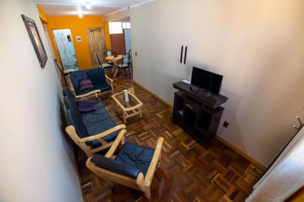 乌尤尼The Little House ApartHotel的享有带椅子和电视的客厅的顶部景色。