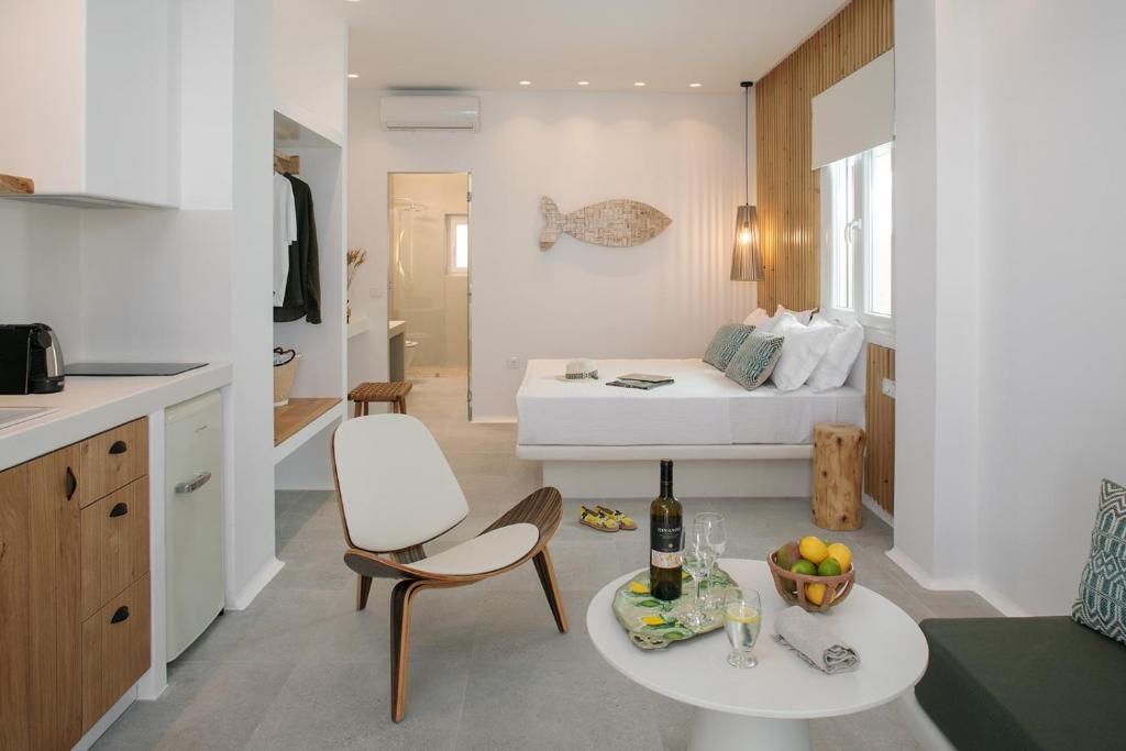 纳克索乔拉Hora Seaside Suites的厨房以及带床和桌子的客厅。