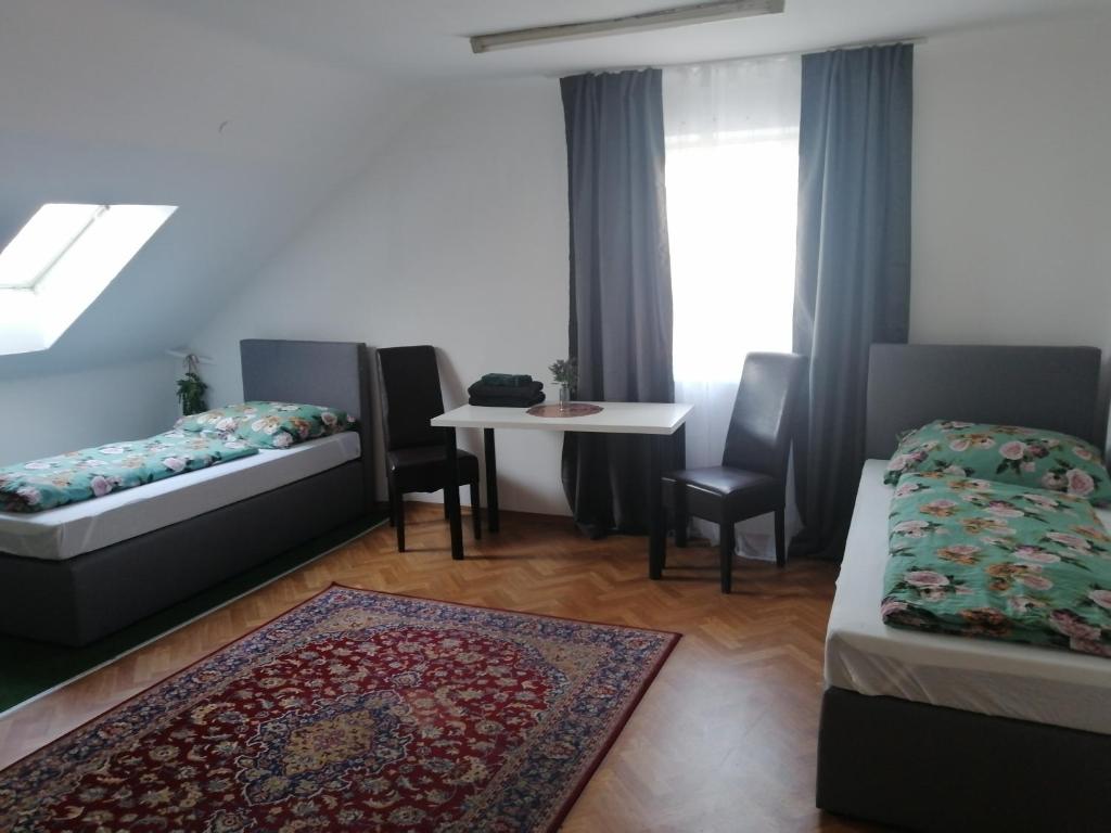 格拉茨ApartGraz的一间客房配有两张床和一张桌椅