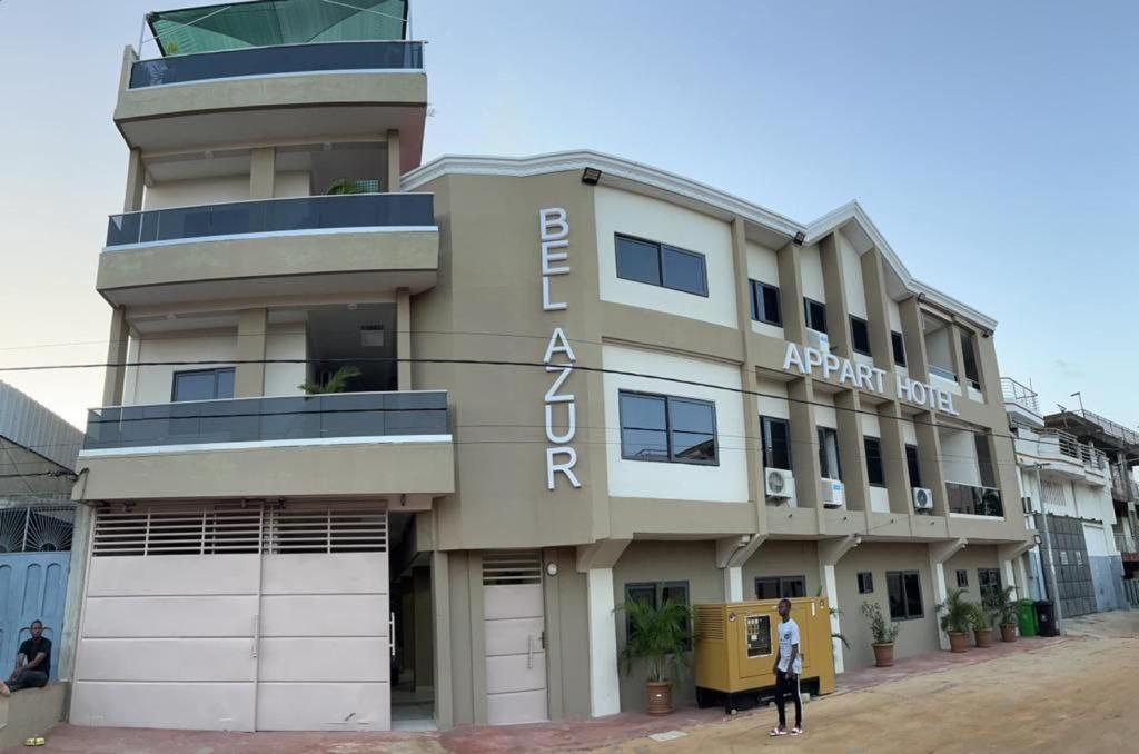 科托努Hotel Bel Azur Cotonou的一座建筑,上面写着阿赫塔尔酒店的话